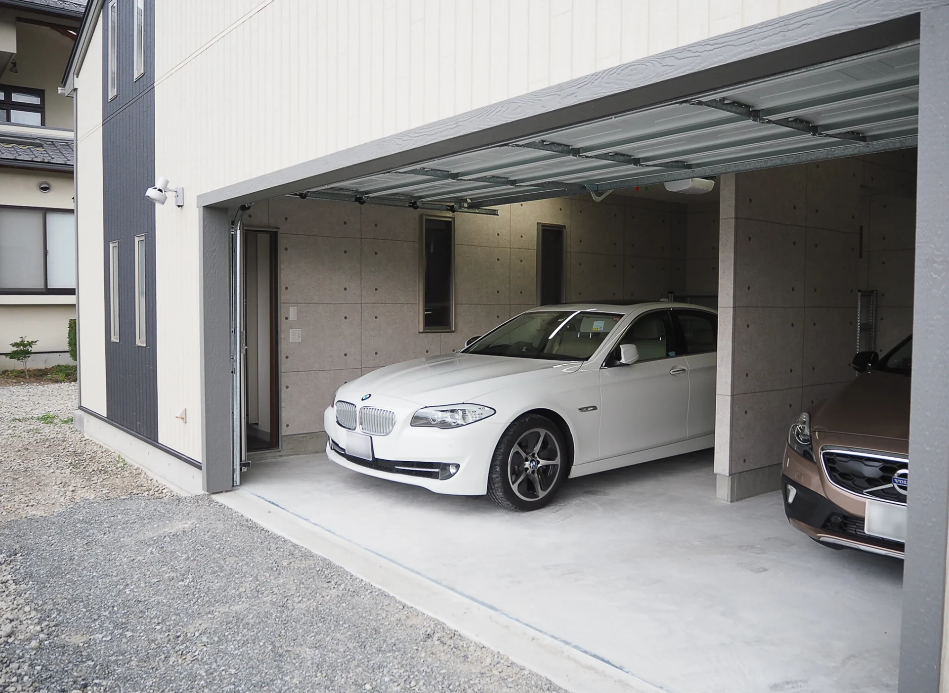 ツートーンのミニマルな外観のガレージ