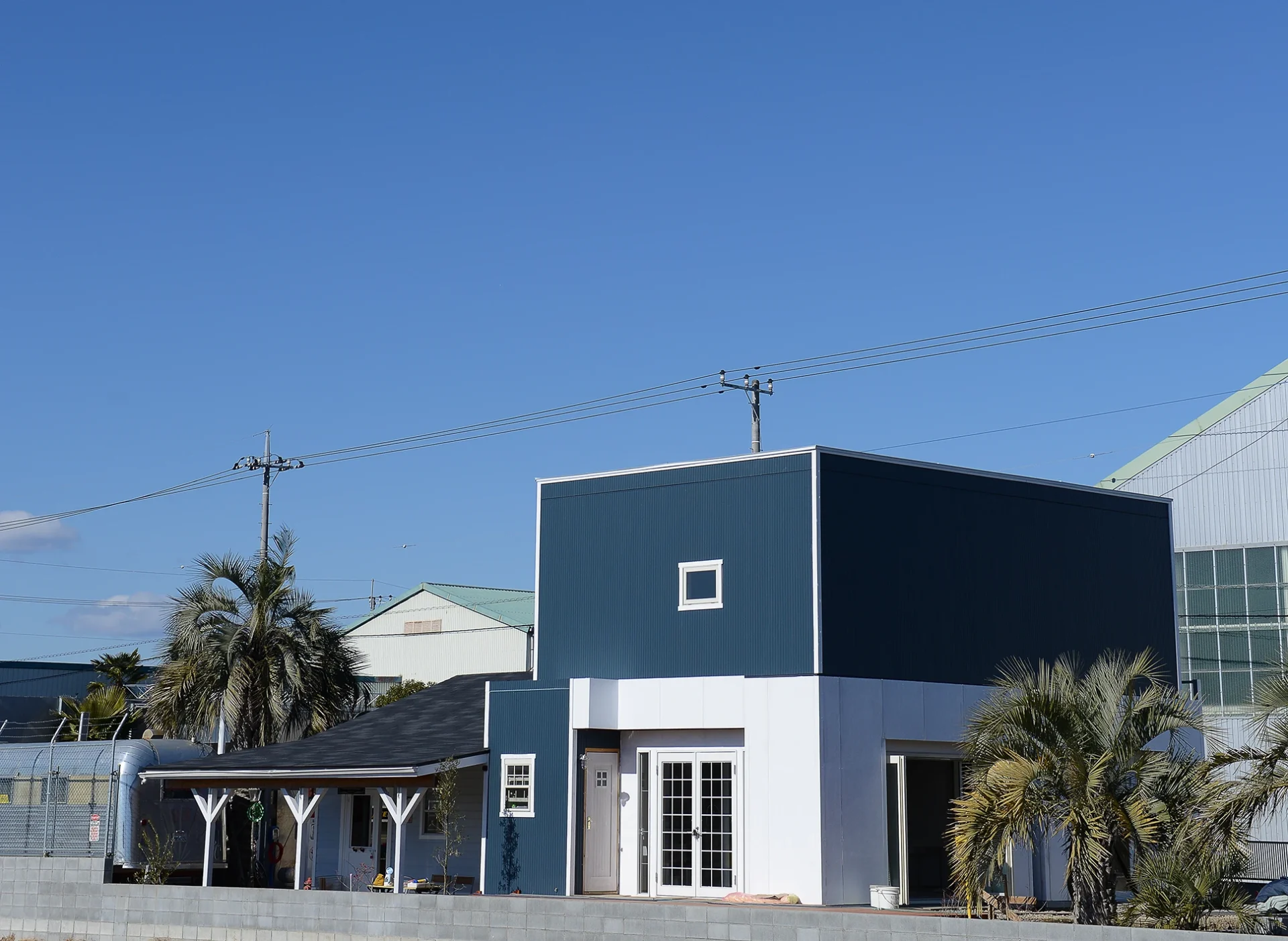 遊び心が詰まったガレージと、その後ろに事務室棟